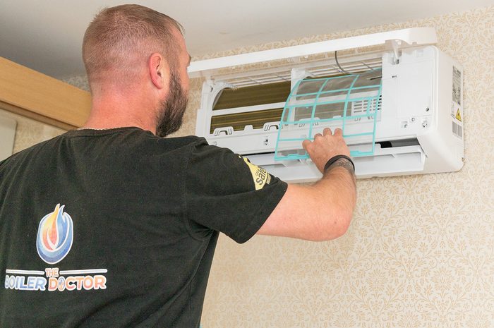 Engineer fitting an air conditioning indoor unit