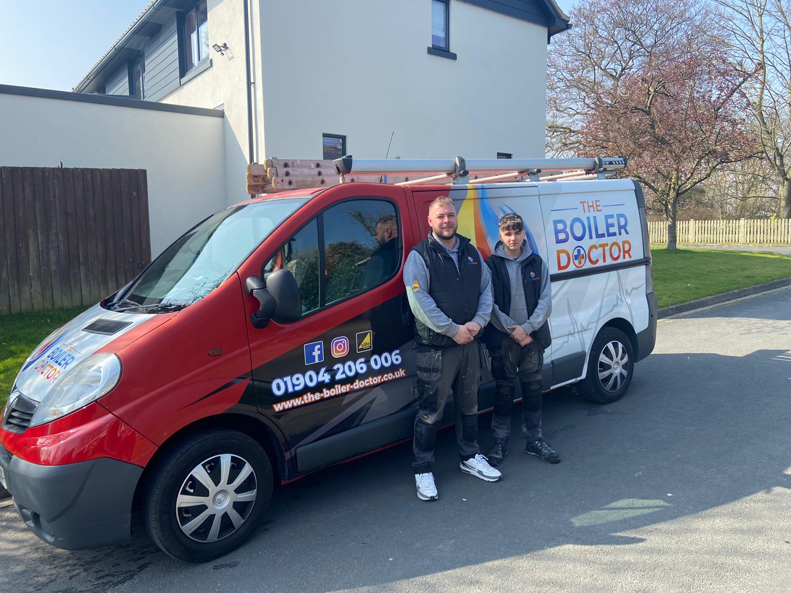 Steve standing next to boiler in branded shirt